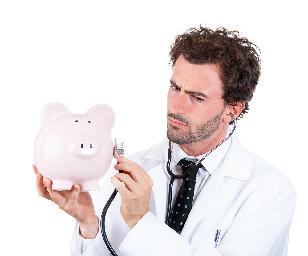 Closeup portrait, young curious male man healthcare professional, doctor, nurse listening to piggy bank with stethoscope. Medical insurance, medicare reimbursement concept . Health-law coverage gap Closeup portrait, young curious male man healthcare professional, doctor, nurse listening to piggy bank with stethoscope. Medical insurance, medicare reimbursement concept . Health-law coverage gap
